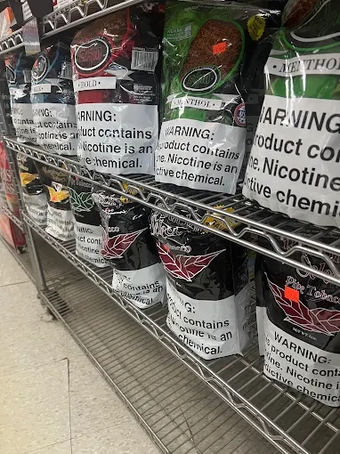 Shelf with bags of pipe tobacco and warning labels